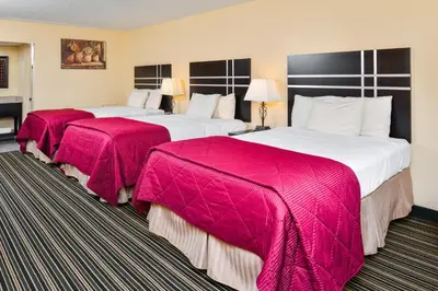two beds in a hotel room with pink blankets at Soudersburg Inn & Suites Lancaster in Ronks