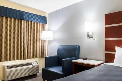 a room with a bed and a chair in a room at Escape Inn Hershey in Hershey