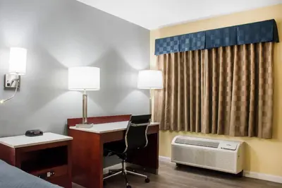 a hotel room with a desk and a bed and a computer at Escape Inn Hershey in Hershey