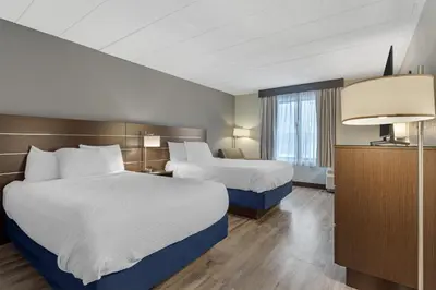 a hotel room with two beds and a lamp at Best Western Hunt's Landing Hotel Matamoras Milford in Matamoras