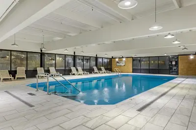 a pool in a room with chairs and a table at Best Western Hunt's Landing Hotel Matamoras Milford in Matamoras