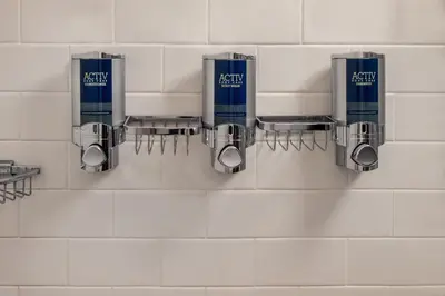 a bathroom with three soap dispensers on a wall at Four Points Philadelphia City Center in Philadelphia