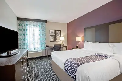 a hotel room with a bed and a flat screen tv at La Quinta by Wyndham York in York