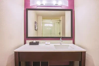 a bathroom with a sink and a large mirror at La Quinta by Wyndham York in York