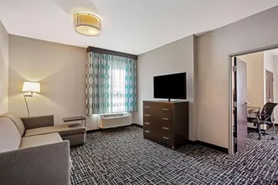 a hotel room with a couch and a flat screen tv at La Quinta by Wyndham York in York