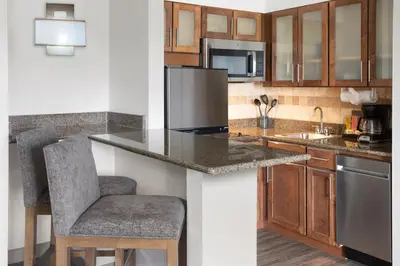 a kitchen with a counter with a sink and a refrigerator at Staybridge Suites Harrisburg-Hershey by IHG in Harrisburg