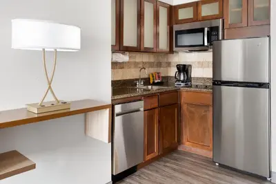 a kitchen with a stainless steel refrigerator and a lamp at Staybridge Suites Harrisburg-Hershey by IHG in Harrisburg