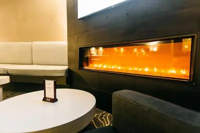 a fireplace in a room with a table and a chair at Crowne Plaza Hotel Harrisburg-Hershey by IHG in Harrisburg