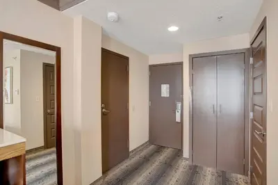 an empty hallway with two doors and a room with wooden floors at Crowne Plaza Hotel Harrisburg-Hershey by IHG in Harrisburg