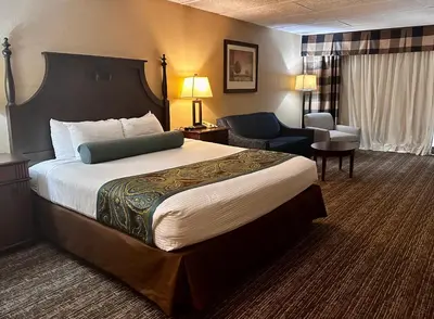 a hotel room with a large bed and a chair at Red Lion Hotel Harrisburg Hershey in Harrisburg