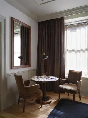a living room with a table and chairs and a window at The Bellevue Hotel, in the Unbound Collection by Hyatt in Philadelphia