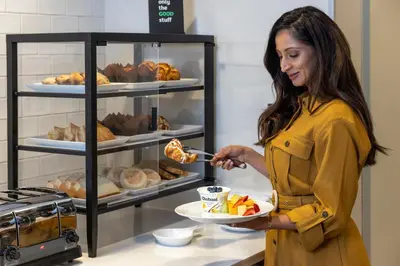 a woman is holding a plate of food at Holiday Inn Lansdale-Hatfield by IHG in Kulpsville