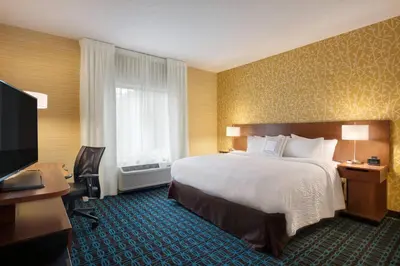 a hotel room with a bed and a desk and a television at Fairfield Inn & Suites by Marriott Lancaster East at The Outlets in Lancaster