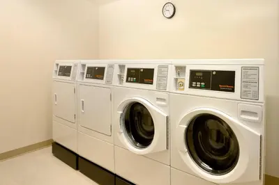 three washing machines and a clock on a wall at Fairfield Inn & Suites by Marriott Lancaster East at The Outlets in Lancaster