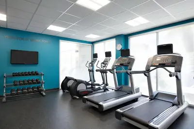 a gym with cardio machines in a room with blue walls at Fairfield Inn & Suites by Marriott Lancaster East at The Outlets in Lancaster