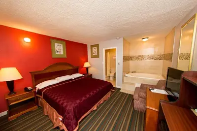 a hotel room with a bed and a bath tub at Scottish Inn and Suites - Bensalem-Philadelphia in Bensalem