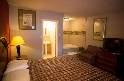 a hotel room with a bed and a bathroom at Scottish Inn and Suites - Bensalem-Philadelphia in Bensalem