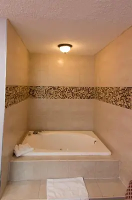 a bathroom with a bath tub in a room at Scottish Inn and Suites - Bensalem-Philadelphia in Bensalem