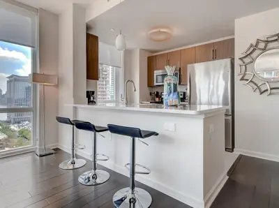 a kitchen with a counter and two stools at a bar at Global Luxury Suites at Newport in Jersey City
