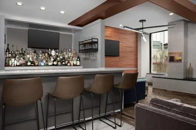 a bar in a room with a couch and chairs at Fairfield Inn & Suites by Marriott New York Manhattan/Central Park in New York