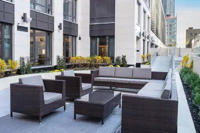 a patio with wicker chairs and tables in a building at Fairfield Inn & Suites by Marriott New York Manhattan/Central Park in New York