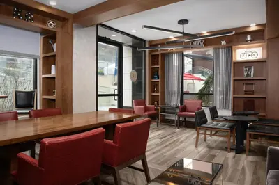 a dining room with a table and red chairs at Fairfield Inn & Suites by Marriott New York Manhattan/Central Park in New York