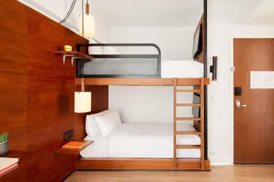 a bunk bed in a small room with a ladder at Arlo NoMad in New York