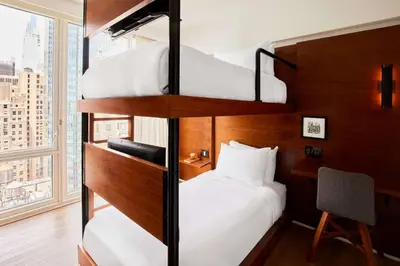 two bunk beds in a hotel room with a window at Arlo NoMad in New York