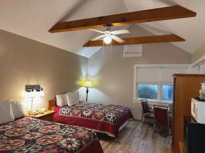 a hotel room with two beds and a ceiling fan at Spruce Lane Lodge and Cottages in Smoketown