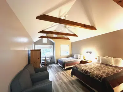 a bedroom with a bed and a couch and a chair at Spruce Lane Lodge and Cottages in Smoketown