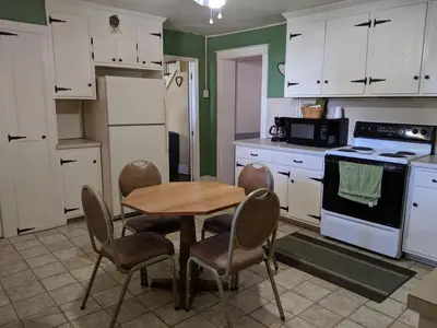 a kitchen with a wooden table and chairs in it at Spruce Lane Lodge and Cottages in Smoketown