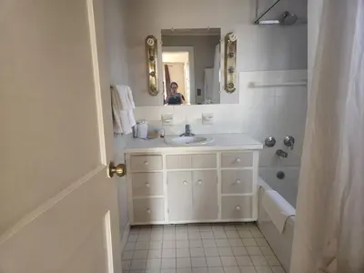a white bathroom with a sink and a mirror at Spruce Lane Lodge and Cottages in Smoketown