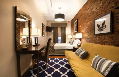 a hotel room with a couch and a desk and a bedroom at Hotel 309 in New York