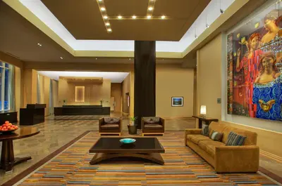a lobby of a hotel with a couch and chairs at Heldrich Hotel and Conference Center in New Brunswick