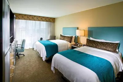 a hotel room with two beds and a television at Heldrich Hotel and Conference Center in New Brunswick