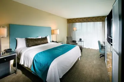 a hotel room with a large bed and a television at Heldrich Hotel and Conference Center in New Brunswick