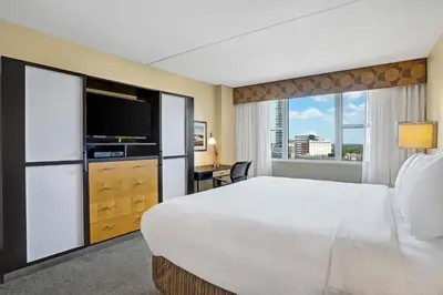 a hotel room with a large bed and a television at Heldrich Hotel and Conference Center in New Brunswick