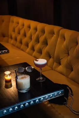 a coffee table with a drink and glasses on a couch at The Rittenhouse Hotel in Philadelphia
