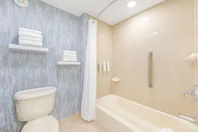 a bathroom with a toilet and a tub and a sink at Homewood Suites by Hilton East Rutherford - Meadowlands, NJ in East Rutherford
