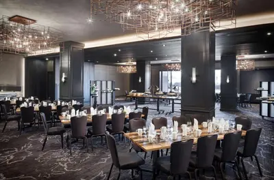 a dining room with tables and chairs and chandeliers at The Logan Philadelphia, Curio Collection by Hilton in Philadelphia