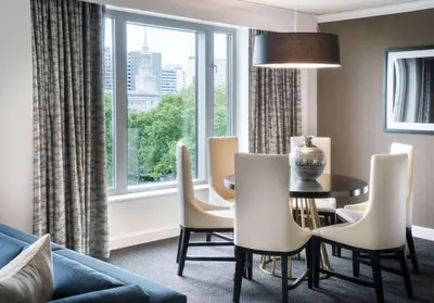 a living room with a table and chairs and a window at The Logan Philadelphia, Curio Collection by Hilton in Philadelphia