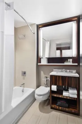 a bathroom with a sink and a toilet and a mirror at Hyatt Grand Central New York in New York