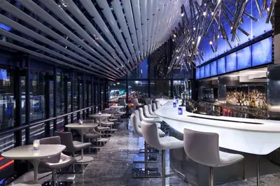 a bar with tables and chairs in a building at Hyatt Grand Central New York in New York