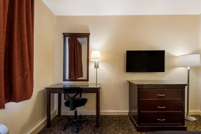 a hotel room with a desk with a mirror and a television at Knights Inn Phildelphia in Philadelphia