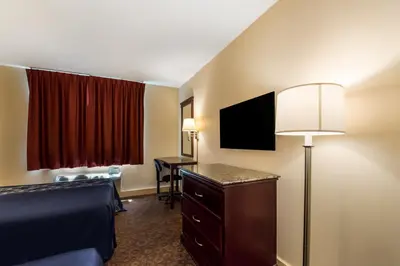 a hotel room with a bedroom with a bed and a desk at Knights Inn Phildelphia in Philadelphia