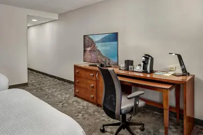 a hotel room with a desk with a computer and a bed at Courtyard Philadelphia/Langhorne in Langhorne