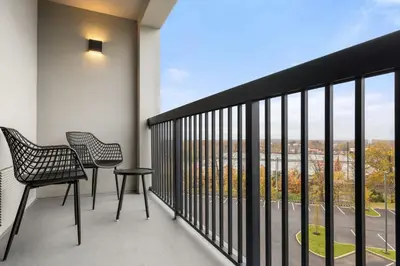 a balcony with two chairs and a view at Courtyard Philadelphia/Langhorne in Langhorne