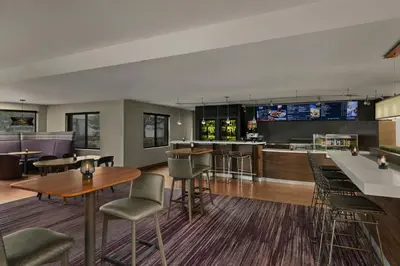 a lobby with tables and chairs and a bar at Courtyard Philadelphia/Langhorne in Langhorne