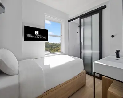 a bathroom with a white bed and a sink at Riverside Tower Hotel in New York