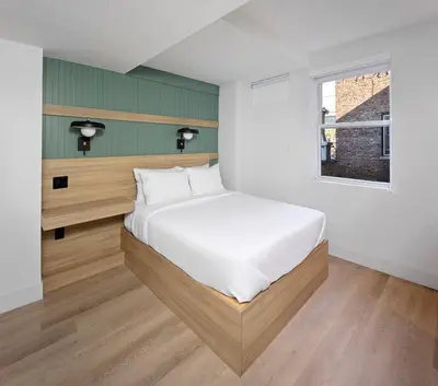 a bedroom with a white bed and a window at Riverside Tower Hotel in New York